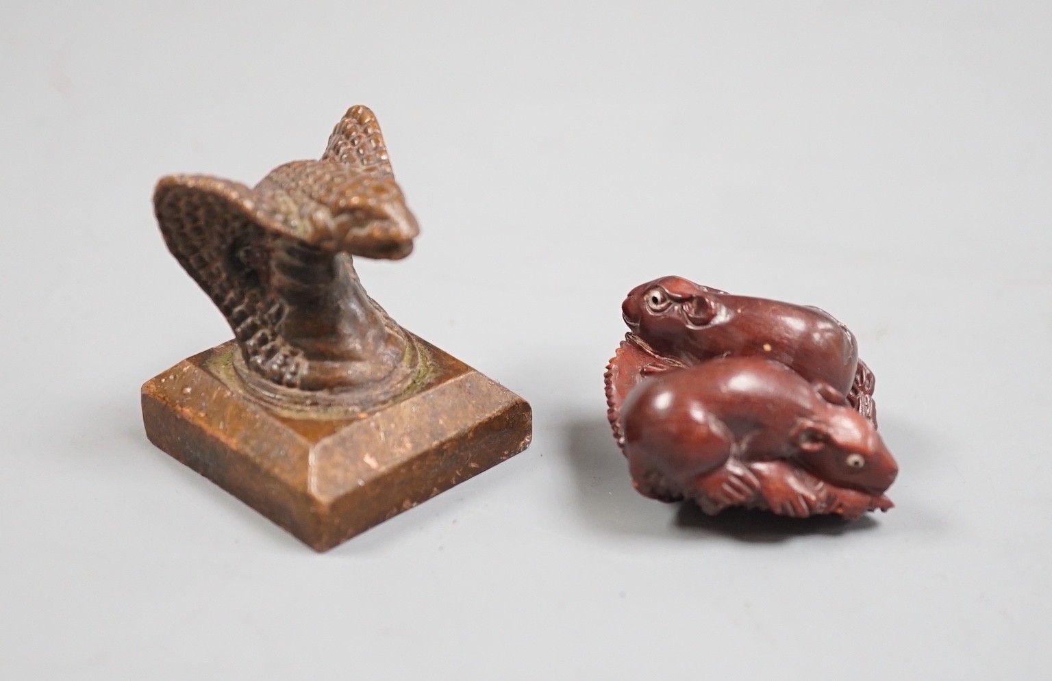 A Chinese bronze 'cobra' seal and a Japanese carved wood netsuke with signed mother of pearl tablet to underside. Seal 4cm tall